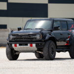 Ford Bronco Raptor Orange Edition elölnézetből, hatalmas FORD felirattal az orron és széles Raptor karosszériával